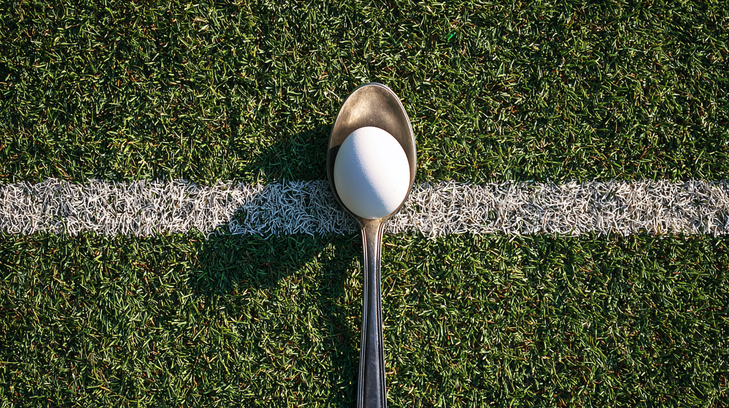 Egg balanced on a spoon on a grass sports field